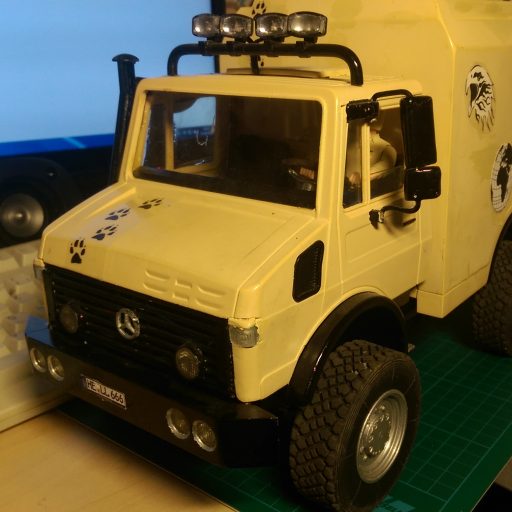 Modell eines Unimogs mit Kofferaufbau in Beige. Bildauschnitt zeigt nur den Bereich des Fahrerhauses